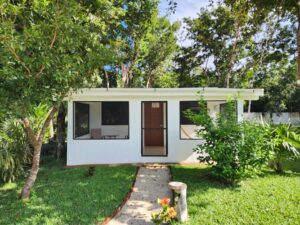 Exterior of a small coastal cottage in Gulfport surrounded by greenery