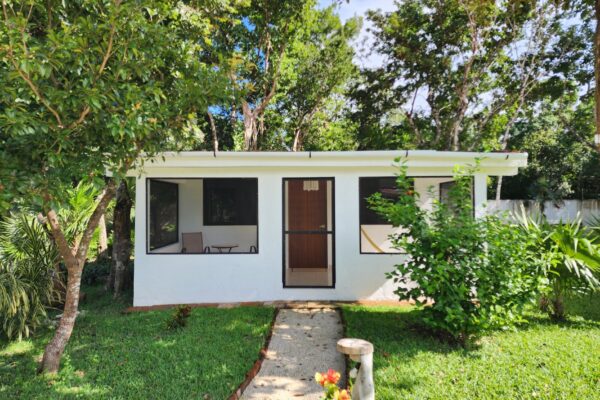 Exterior of a small coastal cottage in Gulfport surrounded by greenery
