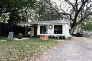 Exterior of a white Florida cottage under mossy oak trees in Gulfport