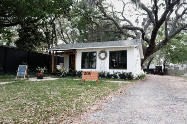 Exterior of a white Florida cottage under mossy oak trees in Gulfport