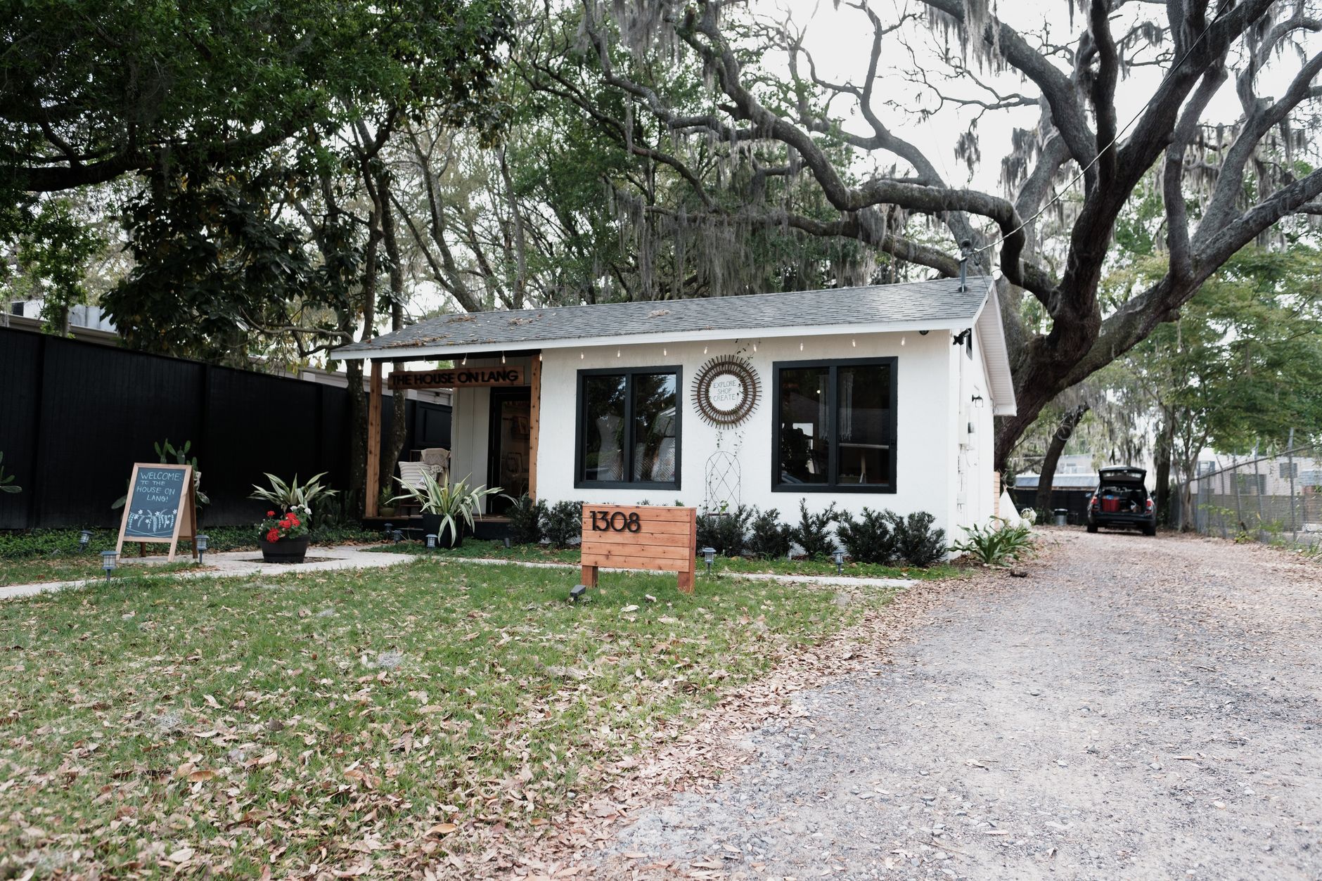 Exterior of a white Florida cottage under mossy oak trees in Gulfport